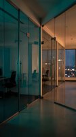Modern office interior with glass partitions and warm lighting creating professional corporate workspace atmosphere for business presentations.