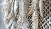 Macrame wall hanging with feathers and rope tassels in boho style. Handcrafted textile art for modern home decor and interior design projects.