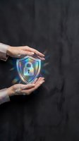 Hands holding glowing holographic shield with padlock icon against dark background, representing cybersecurity, data protection, and digital safety for technology concepts.