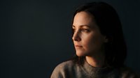 Thoughtful young woman in profile gazing into distance with warm lighting. Professional portrait for wellness, mental health, and lifestyle content.