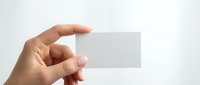 Hand holding blank white business card mockup against light background for branding and corporate identity design projects.