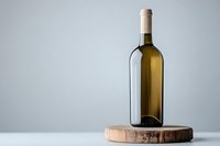 White wine bottle on wooden cutting board against neutral gray background, minimalist composition with soft natural lighting and copy space.