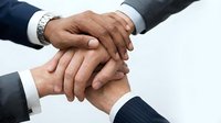 Group of businesspeople stacking hands together in unity, teamwork and collaboration gesture for corporate success and partnership agreement.