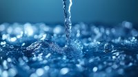 Streaming water splash creating dynamic crown shape with droplets against blurred blue bokeh background, captured in high-speed macro photography.