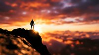 Silhouette of a person standing on a rocky mountain peak against a dramatic golden and orange sunset sky with clouds. Represents achievement, success, and overcoming challenges.