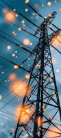High voltage power line tower against blue sky with warm bokeh light overlay, creating atmospheric energy infrastructure scene.