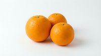 Three fresh ripe oranges grouped together on a white background, showcasing vibrant color and textured skin for food and healthy eating concepts.