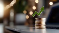 Stack of silver and gold coins with green upward arrow showing growth on laptop keyboard with bokeh lights background, representing financial success and investment return.