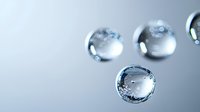 Macro photography of transparent water drops with light refraction and bokeh effect on light gray background, showing surface tension and liquid dynamics.