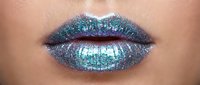 Closeup of lips with shimmering iridescent glitter makeup in blue and green tones, showcasing cosmetic artistry and sparkly lip color application for beauty and fashion.