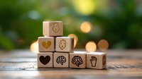 Wooden blocks with emotional intelligence and psychology symbols arranged on rustic surface against blurred green bokeh background, mental health concept.