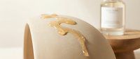 Closeup of gold leaf accents dripping down beige fabric material, luxury textile design element for fashion, interior decor, and upholstery projects.