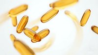 Golden omega-3 fish oil capsules floating in air against white background. Dietary supplements for health and wellness nutrition support.