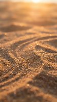 Close-up of golden sand with rippled texture and warm sunlight, suitable for travel, nature, and beach-themed designs and backgrounds.