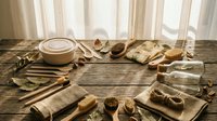 Eco-friendly zero waste bathroom and kitchen essentials arranged on rustic wooden table with natural light, sustainable living concept.