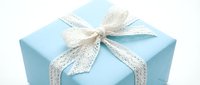 Light blue gift box with white lace ribbon bow on clean background for celebrations, holidays, birthdays, and special occasions packaging design.