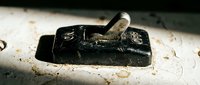 Vintage black metal woodworking plane tool on dusty workshop surface with wood shavings, traditional carpentry equipment for furniture making and craftsmanship.
