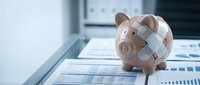 Pink piggy bank with bandage on financial documents and charts representing economic recovery, budget repair, and financial healing concepts for business planning.