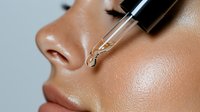 Close up of facial serum application with glass dropper on glowing skin, showing hydrating skincare routine and moisturizing treatment for beauty and wellness.
