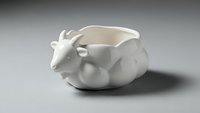 White ceramic cow-shaped bowl or planter with smooth finish on neutral background for kitchen decor and tableware design projects.