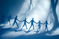 Paper cut silhouettes of people holding hands in chain on blue background with dramatic lighting and shadows, representing unity and community support.