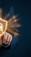 Businessman finger touching glowing digital security shield with padlock icon representing cybersecurity protection and data safety in modern technology.