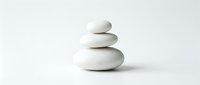 Stacked white stones balanced in zen tower formation on neutral background, symbolizing harmony, meditation, wellness and mindfulness for spa and relaxation design projects.