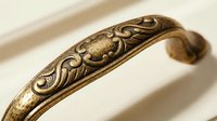 Ornate bronze cuff bracelet with intricate floral engravings and vintage patina finish on neutral background for jewelry design and fashion accessories.