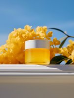 Yellow cosmetic cream jar with orchids on bright background, luxury skincare product photography for beauty and wellness advertising campaigns.
