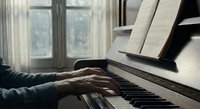 Pianist hands playing upright piano with sheet music in sunlit room. Musical instrument practice session for learning and entertainment at home.