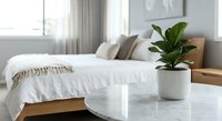 Modern minimalist bedroom interior with wooden bed frame, white bedding, green fiddle leaf fig plant in ceramic pot on marble nightstand for home decor.