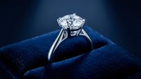 Elegant diamond engagement ring with brilliant cut stone in platinum setting on luxury blue velvet jewelry box for wedding proposal and romance.