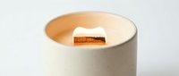 Wooden wick soy candle in a minimalist ceramic jar, soft warm glow, cozy home decor and wellness lifestyle concept.