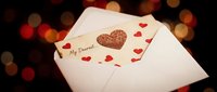 Opened envelope with my dearest text, glittery heart and red hearts on white paper against warm bokeh background for love, romance and Valentine's Day designs.