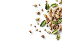 Scattered pistachio nuts and green shells on white background with copy space, overhead view. Food photography for healthy snacks and nutrition.
