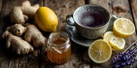 Herbal tea with honey, ginger, lemon and lavender on rustic wooden table. Natural remedy for cold and flu season.