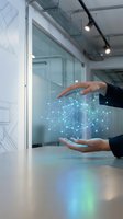 Businessman hands protecting glowing digital network sphere with connected dots in modern office environment representing data security and technology innovation.