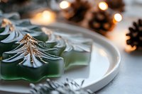 Festive holiday table setting with green star-shaped soap or candle decorated with gold dragonfly, surrounded by pinecones and warm bokeh lights, perfect for seasonal decorating and event styling.