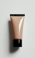Beige foundation tube with black cap isolated on neutral background for cosmetic product photography and beauty marketing materials.