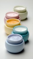 Colorful jars of skincare creams and moisturizers in pastel containers arranged on white background for beauty product photography.