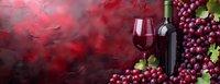 Red wine glass and bottles with fresh grape clusters on dark textured background with dramatic lighting and copy space for wine menu or tasting event.