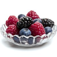 Fresh mixed berries including raspberries, blackberries and blueberries served in elegant glass bowl on white background, macro food photography.
