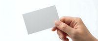 Hand holding blank gray business card mockup on white background for branding and corporate identity design projects.