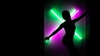 Silhouette of dancing woman against vibrant neon lights in green and purple colors creating dynamic nightclub atmosphere for entertainment design.