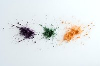 Colorful powder explosion in purple, green and orange scattered on white background, creating dynamic splatter effect for cosmetic and art projects.