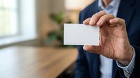 Middle-aged man with medium skin tone wearing dark business suit holding blank white card in hand, suitable for corporate identity, networking, and professional branding materials.