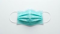 Turquoise surgical face mask with elastic ear loops isolated on white background, ready for healthcare, medical, and safety design projects.