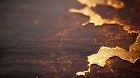 Golden abstract liquid metal texture on dark background with glowing particles and shimmering surface creates luxurious artistic composition.