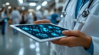 Female doctor in white coat examining brain scan results on digital tablet in hospital corridor, medical staff visible in background, modern healthcare technology.