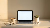 Modern laptop with blank white screen on minimalist desk setup with coffee cup and succulent plant in warm natural lighting for workspace mockup design.